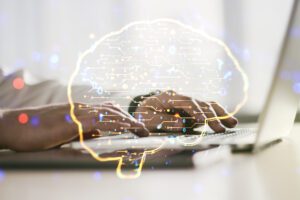Digitised, AI-powered brain graphic overlaying hands typing on a keyboard to represent bidding with AI